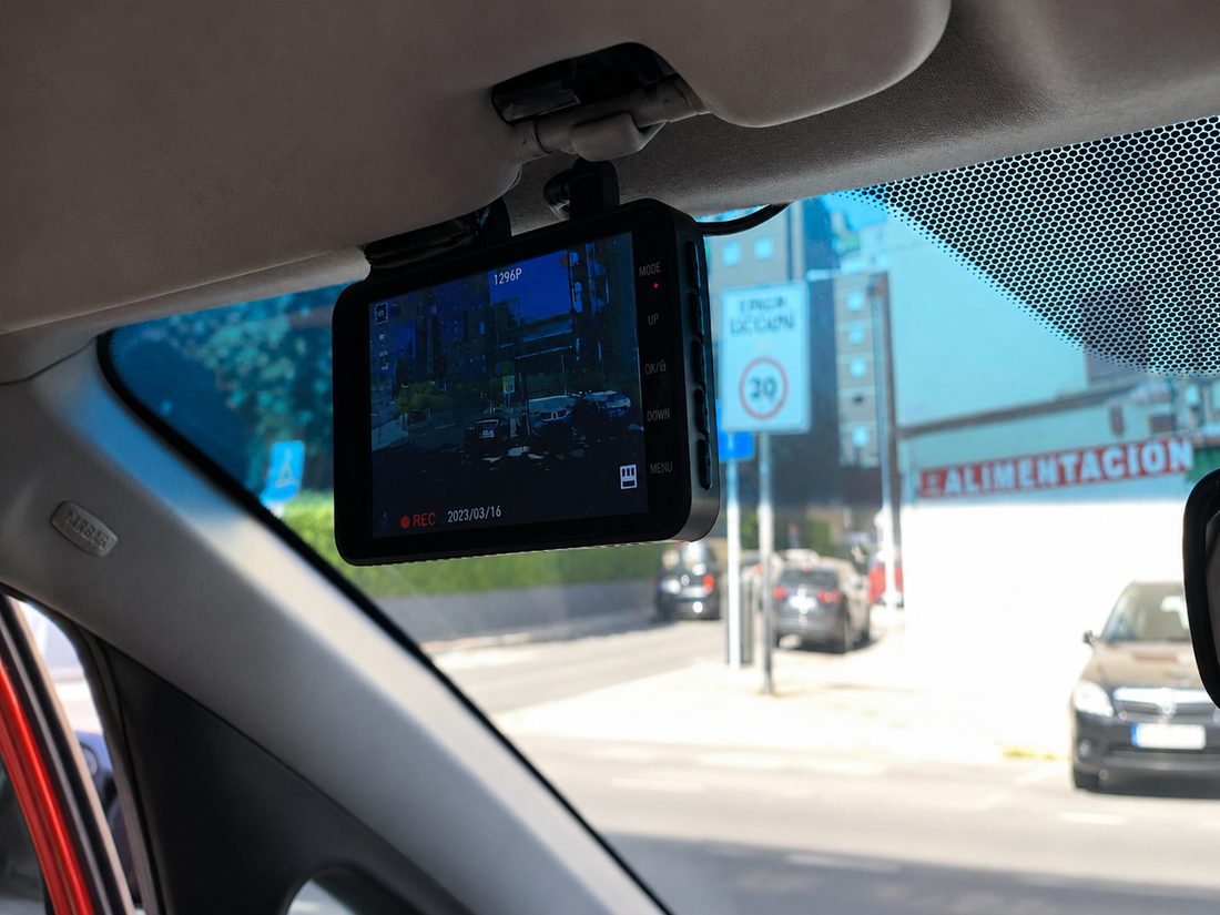 Dashcam montada detrás del retrovisor, encendida y grabando (REC)